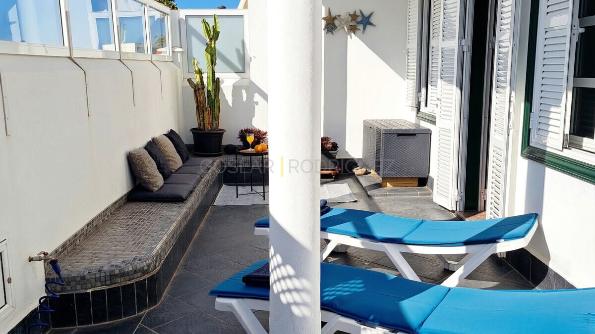 Geräumige Terrasse mit eingebauten Sitzgelegenheiten, Sonnenliegen und Kakteengarten.