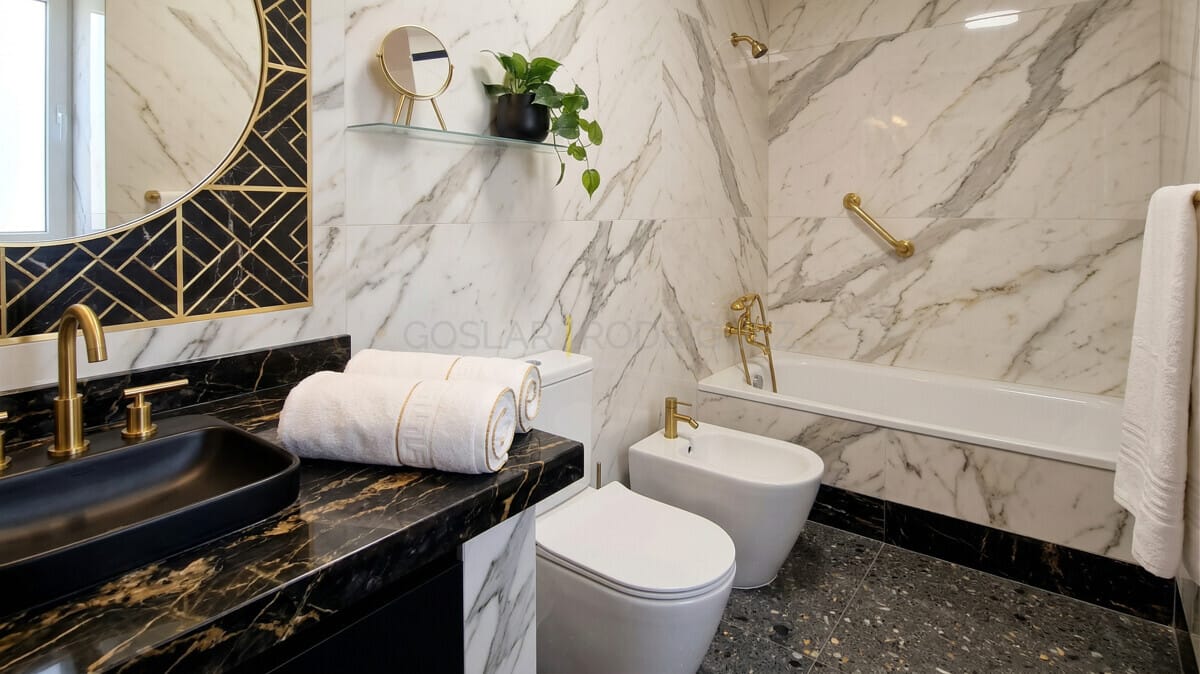 Modernes Luxusbad mit Marmor, Goldarmaturen, schwarzem Waschbecken & Waschtisch.