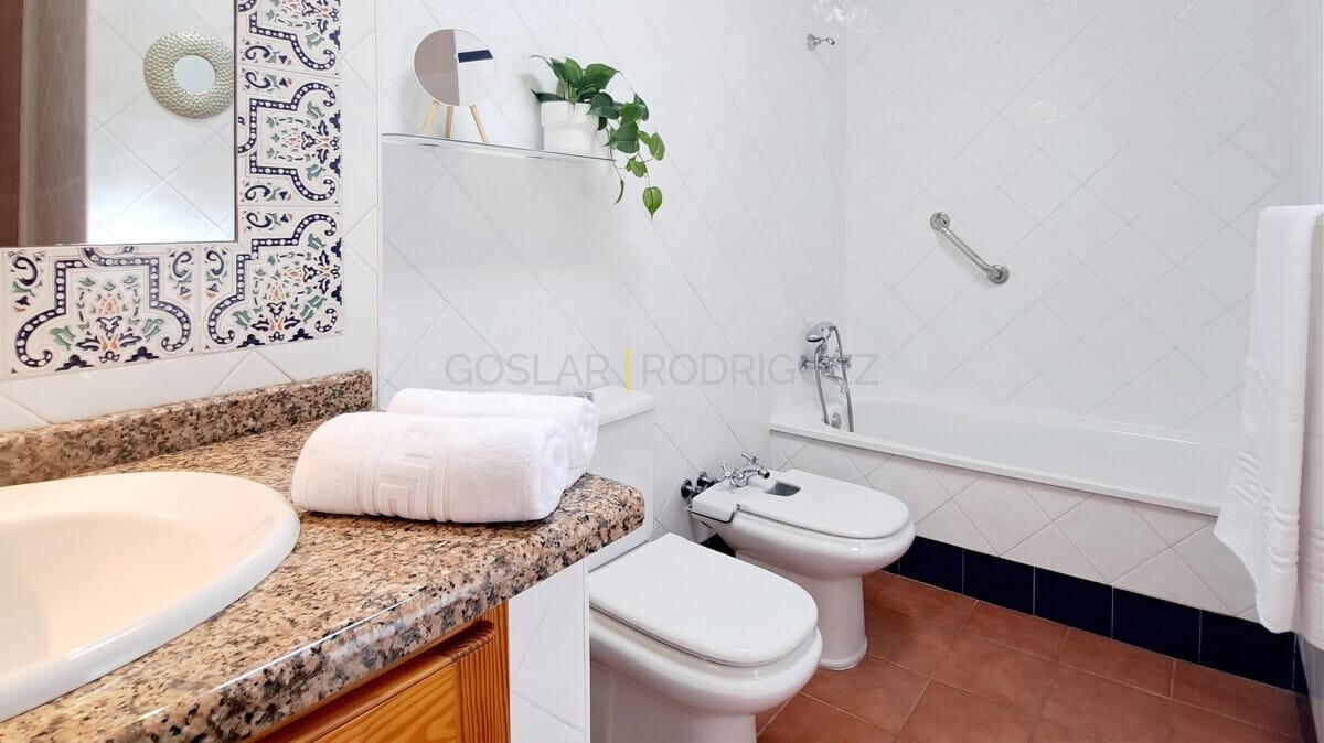 Helles Badezimmer mit Deko-Fliesen, Bidet, Waschbecken und Badewanne. Bietet ein sauberes und luftiges Gefühl.