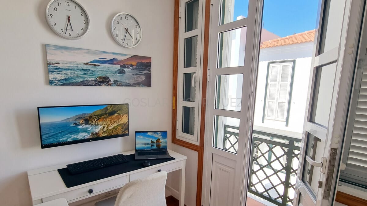 Heimbüro mit Computer, Laptop und Meereskunst. Hell, modern, mit Balkonzugang.