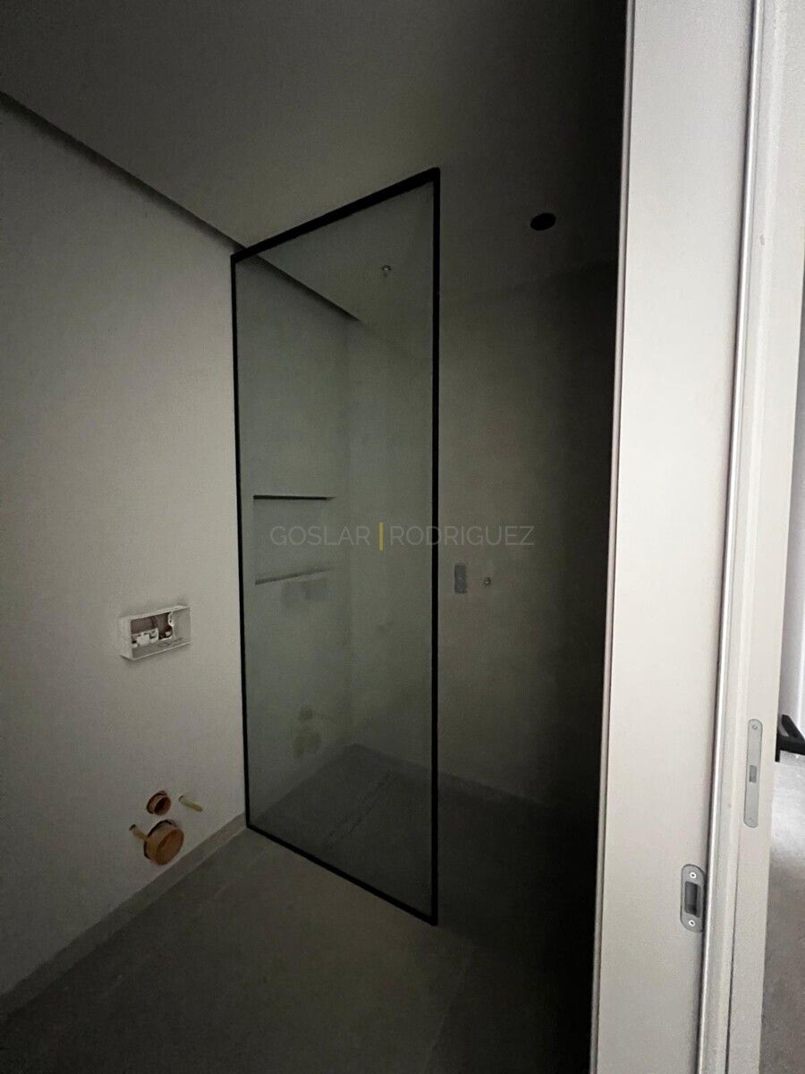 Badezimmer einer Villa in Adeje auf Teneriffa. Helle Fliesen, moderne Dusche mit Glaswand.