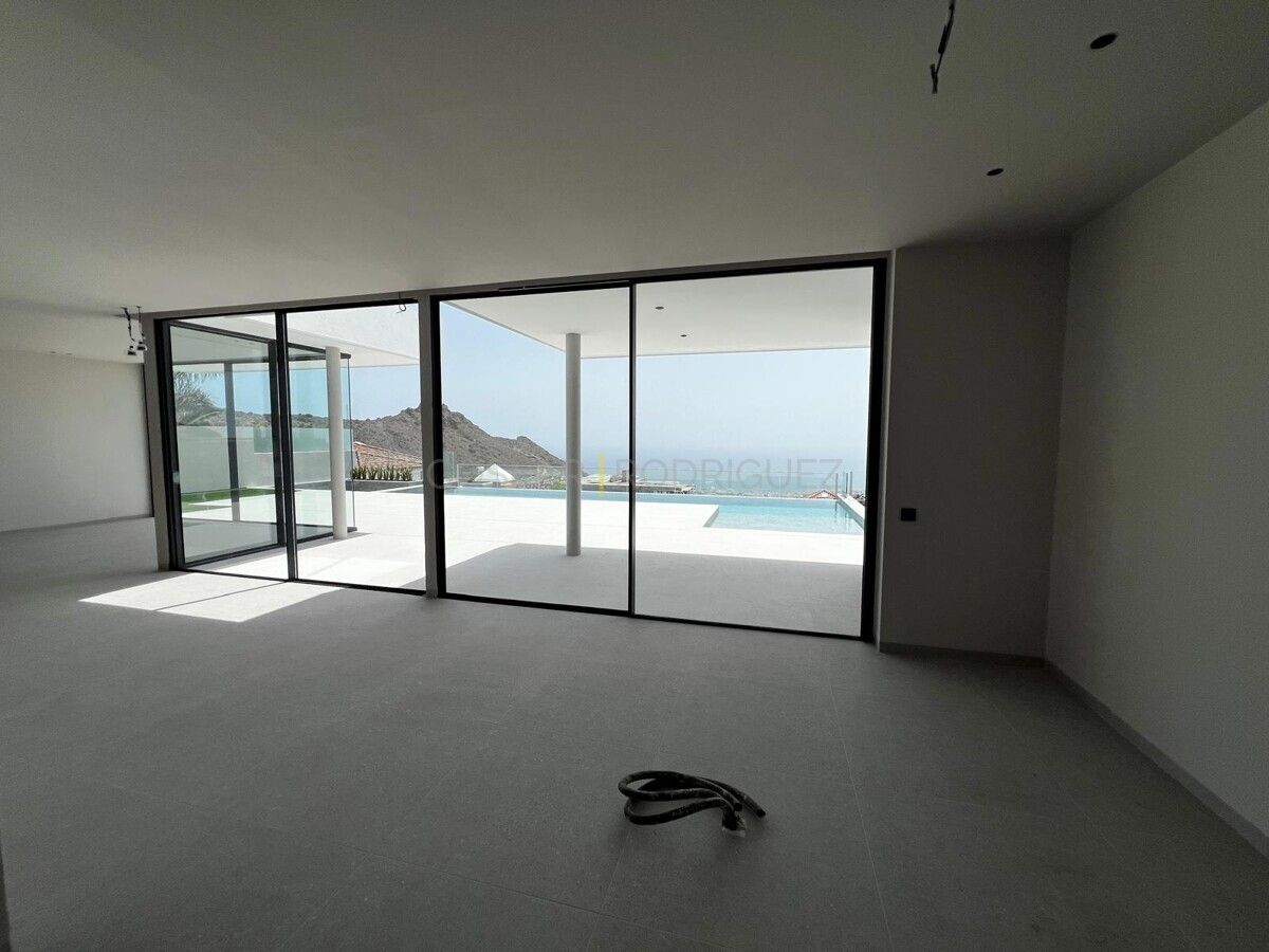 Heller, moderner Raum mit großem Fenster zum tropischen Garten. Villa in Adeje auf Süd-Teneriffa. Perfekt für Liebhaber von Villen mit viel Licht und Grün.