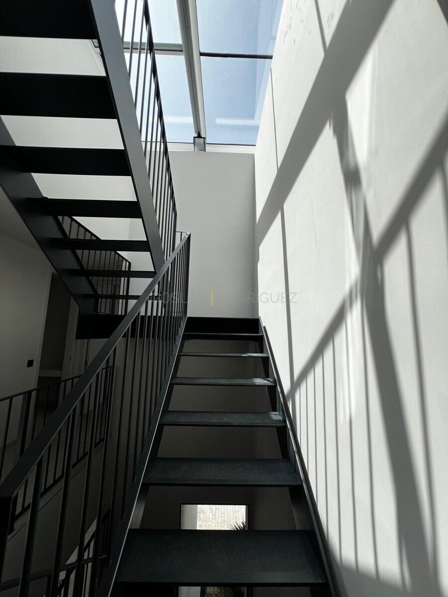 Innenaufnahme einer modernen Treppe mit schwarzem Geländer und Oberlicht in einer Villa in Adeje im Süden von Teneriffa.