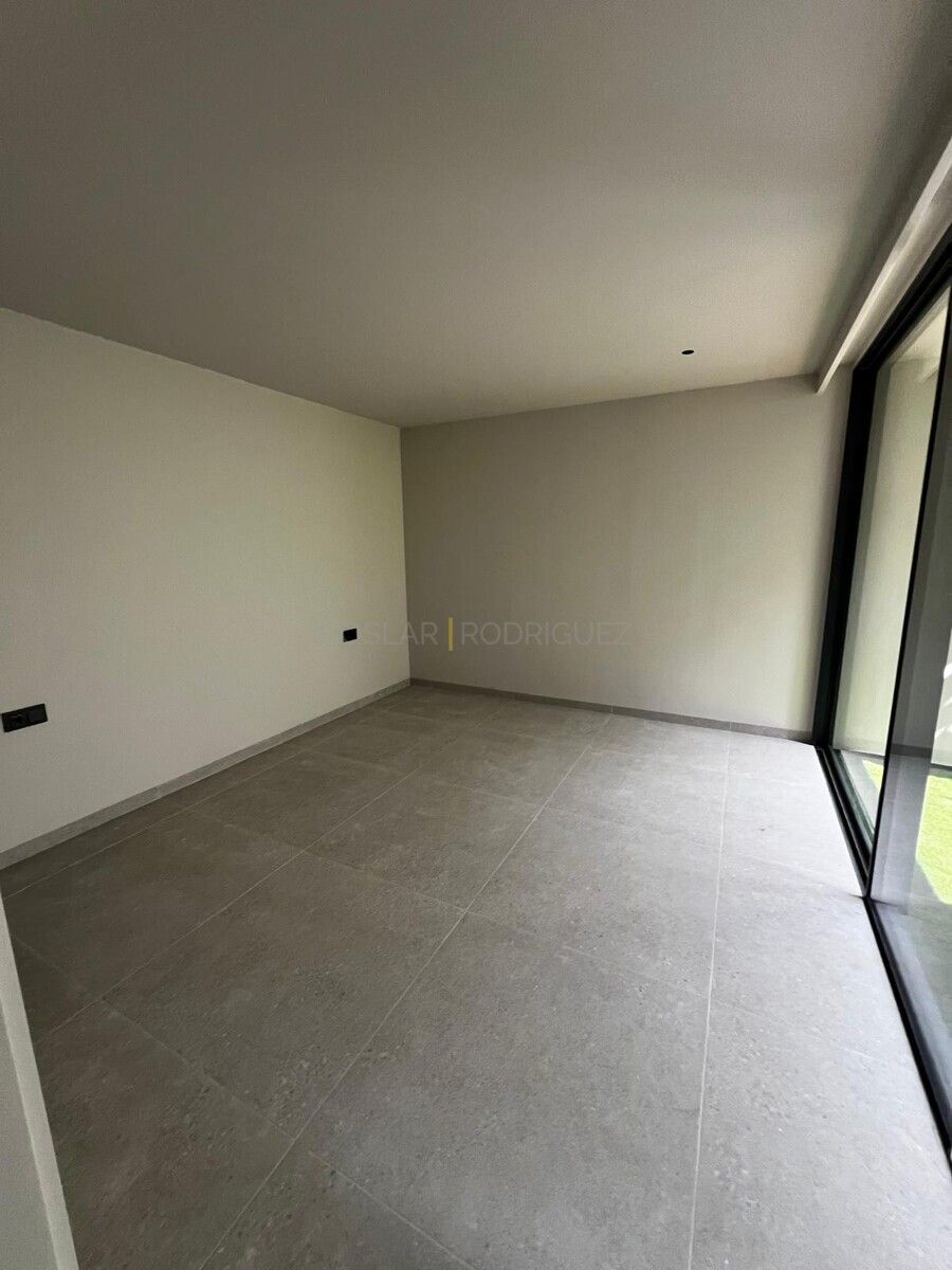 Leeres Zimmer mit grauen Fliesen und großem Fenster in einer Villa in Adeje, Teneriffa.