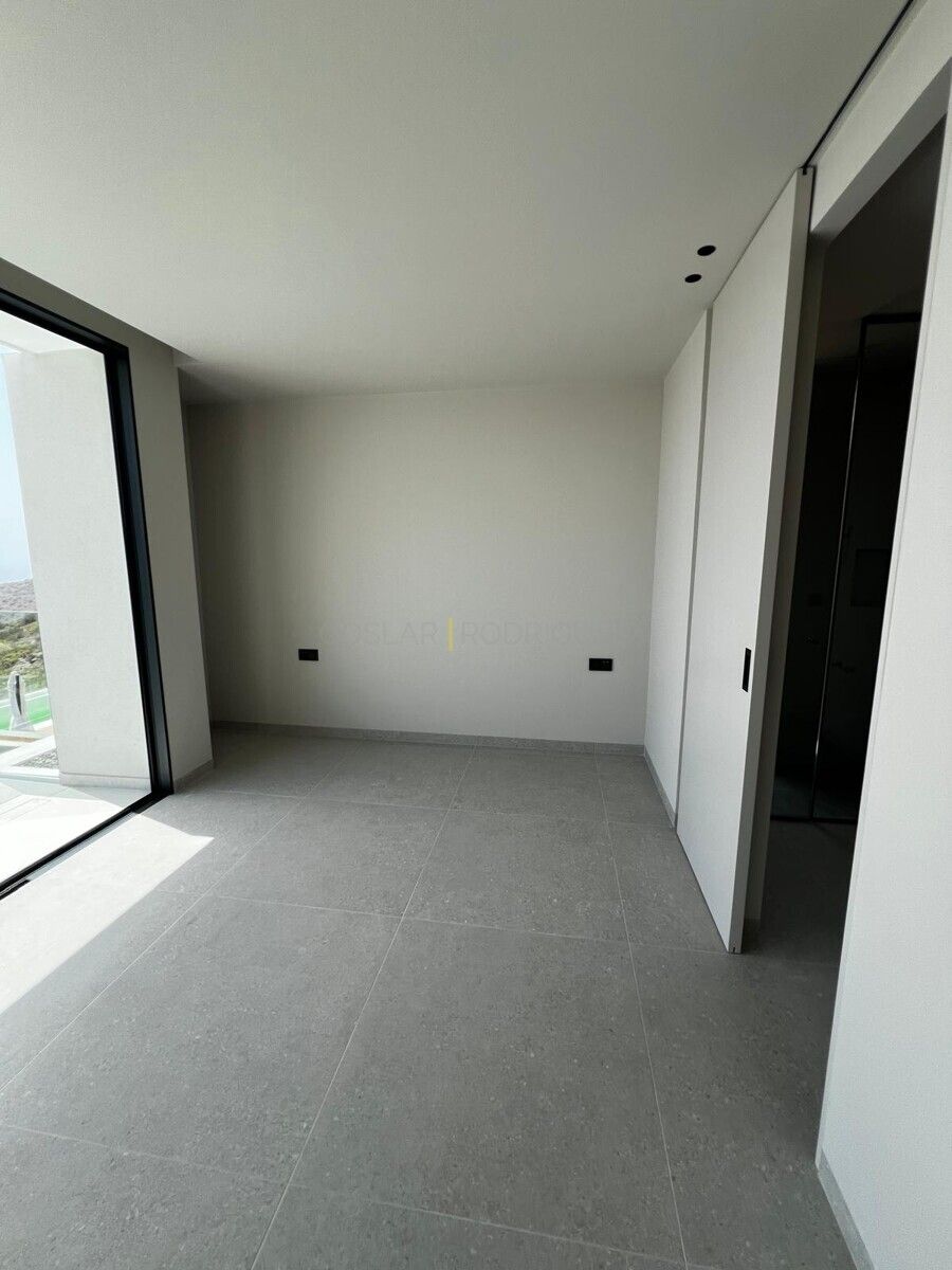 Helles, modernes Schlafzimmer mit Fensterfront und gefliestem Boden in einer Villa in Adeje auf Teneriffa.