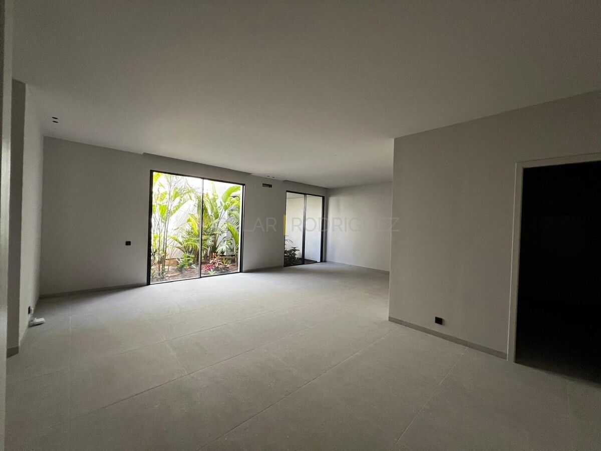 Heller, moderner Raum mit großem Fenster zum tropischen Garten. Villa in Adeje auf Süd-Teneriffa. Perfekt für Liebhaber von Villen mit viel Licht und Grün.