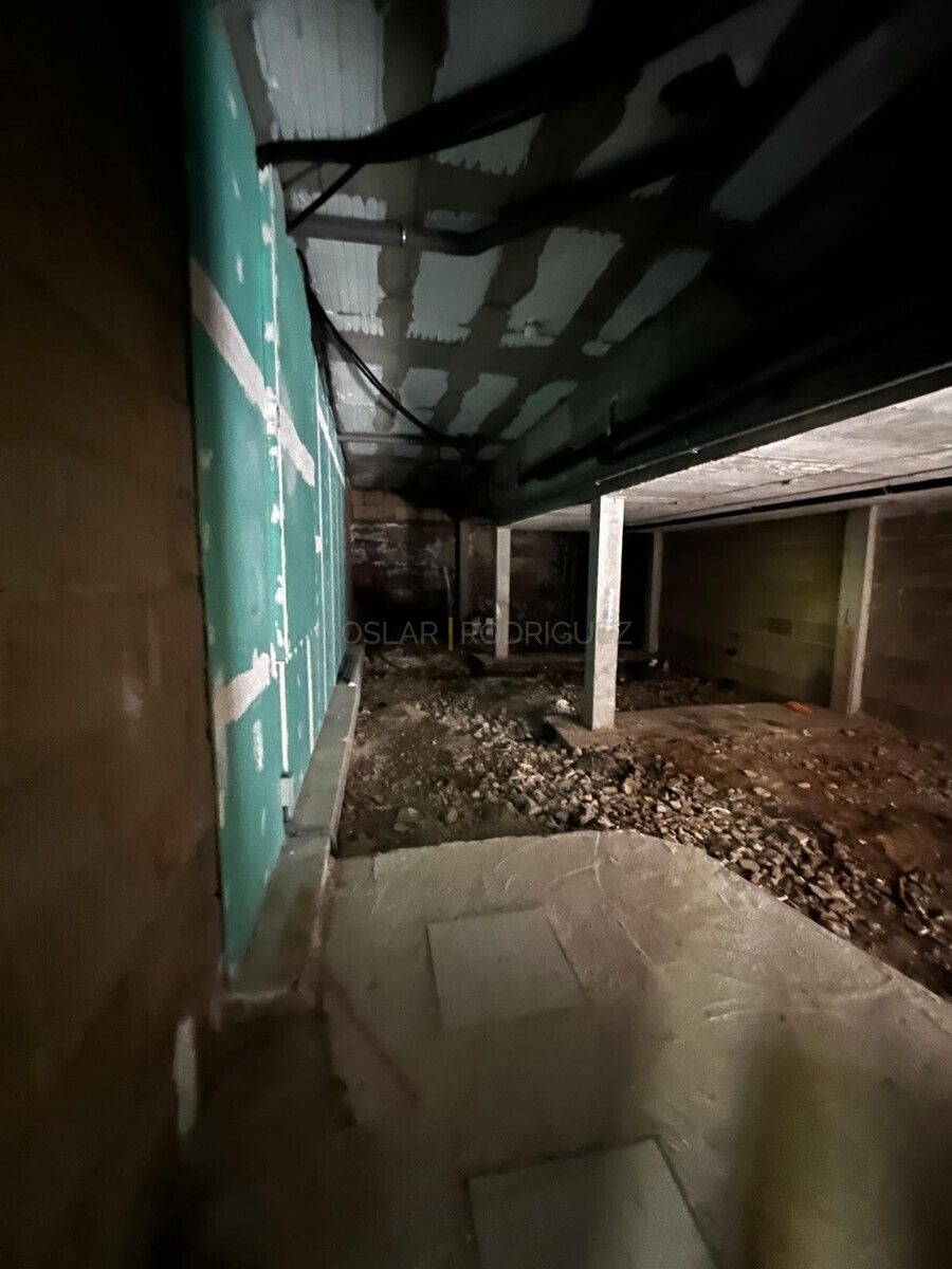 Rohbau-Ansicht einer Villa in Adeje, Teneriffa. Blick in einen noch nicht fertiggestellten Raum mit Betonstützen, unebenem Boden und vorbereitenden Wandinstallationen.