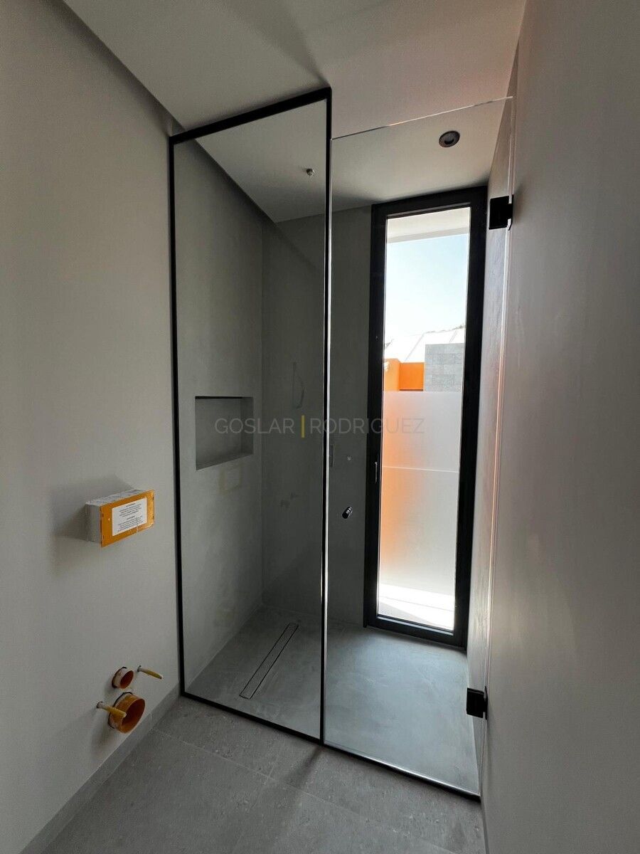 Moderne Dusche mit Glaswand in einer Villa in Adeje auf Teneriffa. Blick durch das Fenster auf die Umgebung.