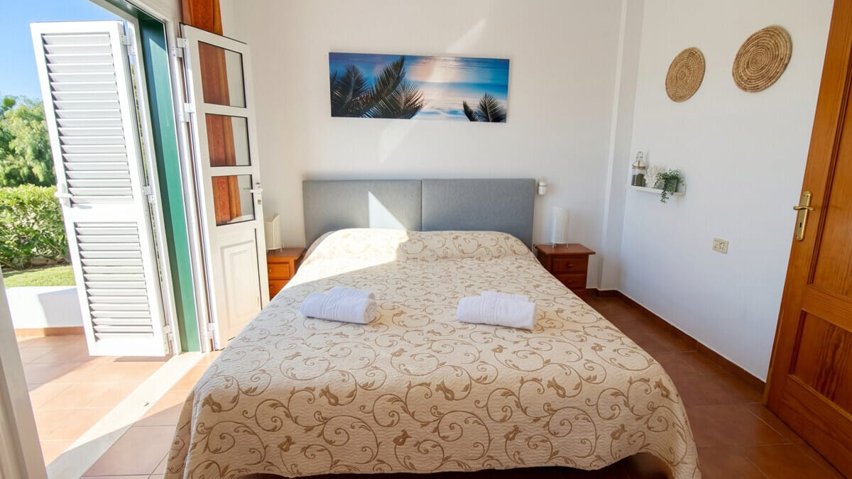 Helles Schlafzimmer auf Teneriffa mit Doppelbett und Terrassenzugang.