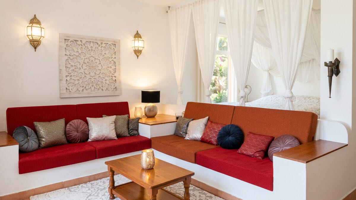 Innen-Sitzbereich in Villa auf Teneriffa mit roten Sofas und Wanddeko.