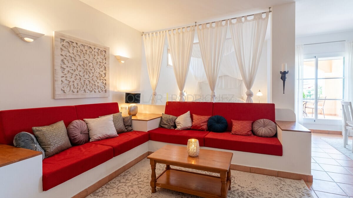 Spacious living area with red sofas and intricate wall art in Tenerife villa.