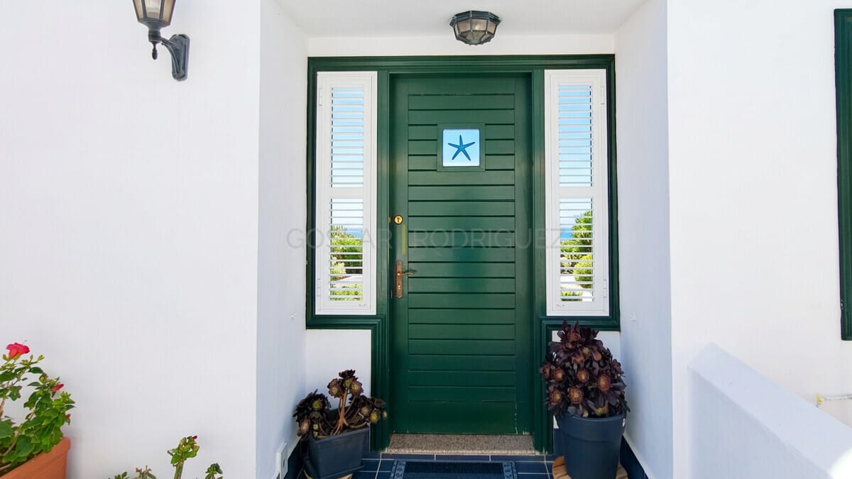 Front door of a modern villa in Abades, Tenerife, with sea view and plants.