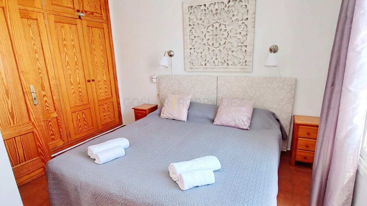 Comfortable bedroom with wooden closet and decorative wall art.