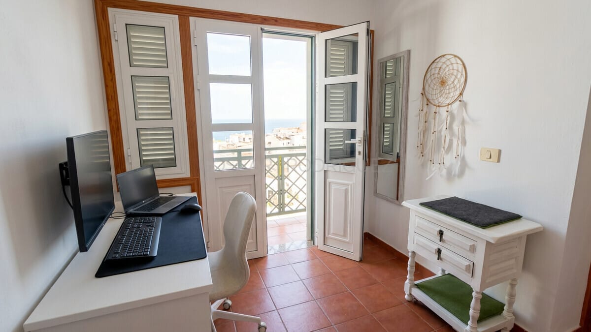 Room with desk, laptop, and balcony overlooking Abades, Tenerife.
